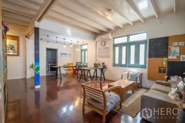 บ้าน ให้เช่าในKhlong Toei, Bangkok - พื้นที่รับแขกและทำงานแบบโอเพ่น พื้นไม้ ฝ้าคาน โซฟา และหน้าต่างบานใหญ่