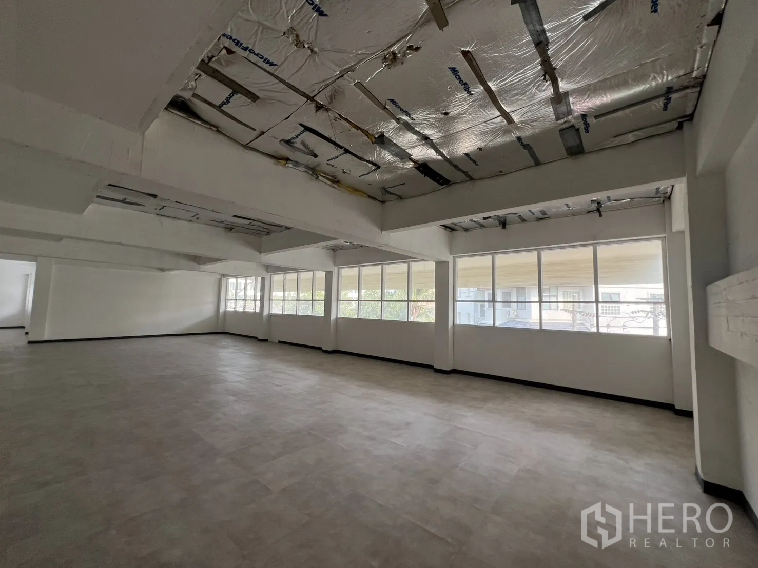 办公空间 出租在Watthana, Bangkok - 整面落地窗的明亮办公区，天花保温材料外露。