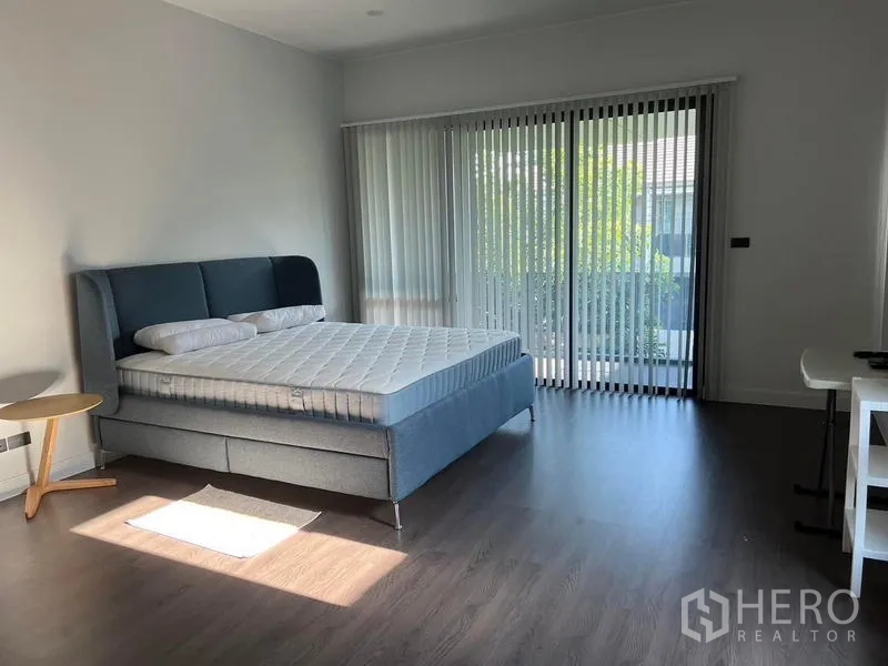 Detached House for rent in Bang Kapi, Bangkok - Spacious master bedroom with floor-to-ceiling sliding doors, vertical blinds and balcony view.