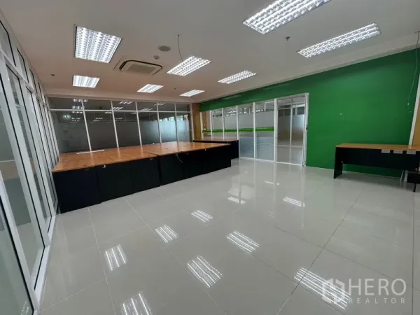 Office Space for rent in Suan Luang, Bangkok - Spacious office area featuring LED grid lighting, a green accent wall and built-in wood workstations.