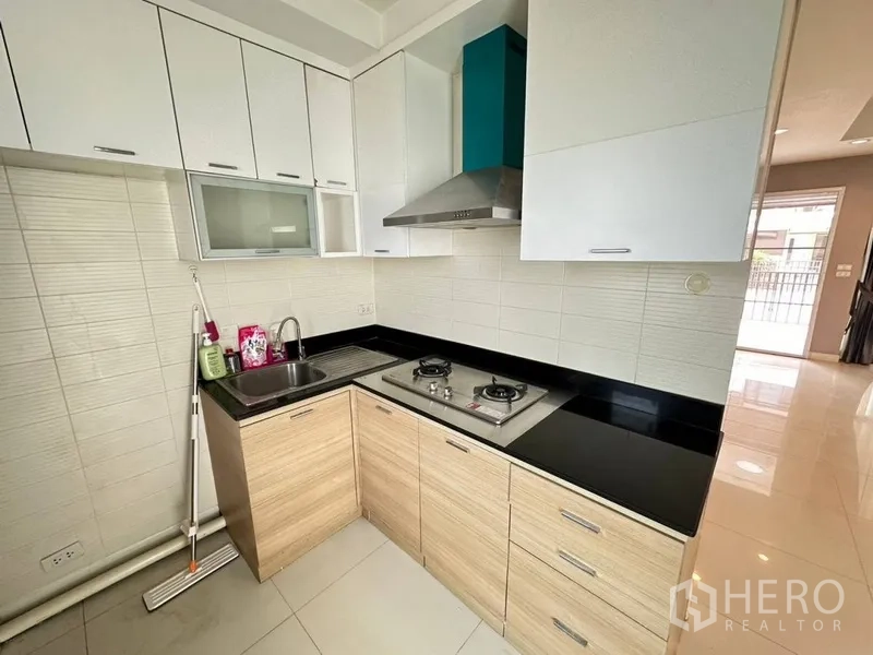 ทาวน์เฮาส์ ให้เช่าหรือขายในPhra Khanong, Bangkok - ครัวรูปตัวแอล เตาแก๊ส เครื่องดูดควัน และท็อปหินสีดำ