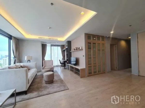 Condominium for sale - Wide living area with sofa, ottomans, work desk and large windows.