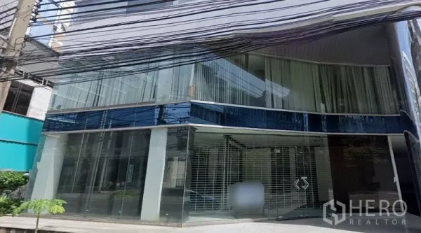 零售空间 出租在Sathon, Bangkok - 临街零售铺面，弧形落地玻璃立面与安全金属栅栏入口。