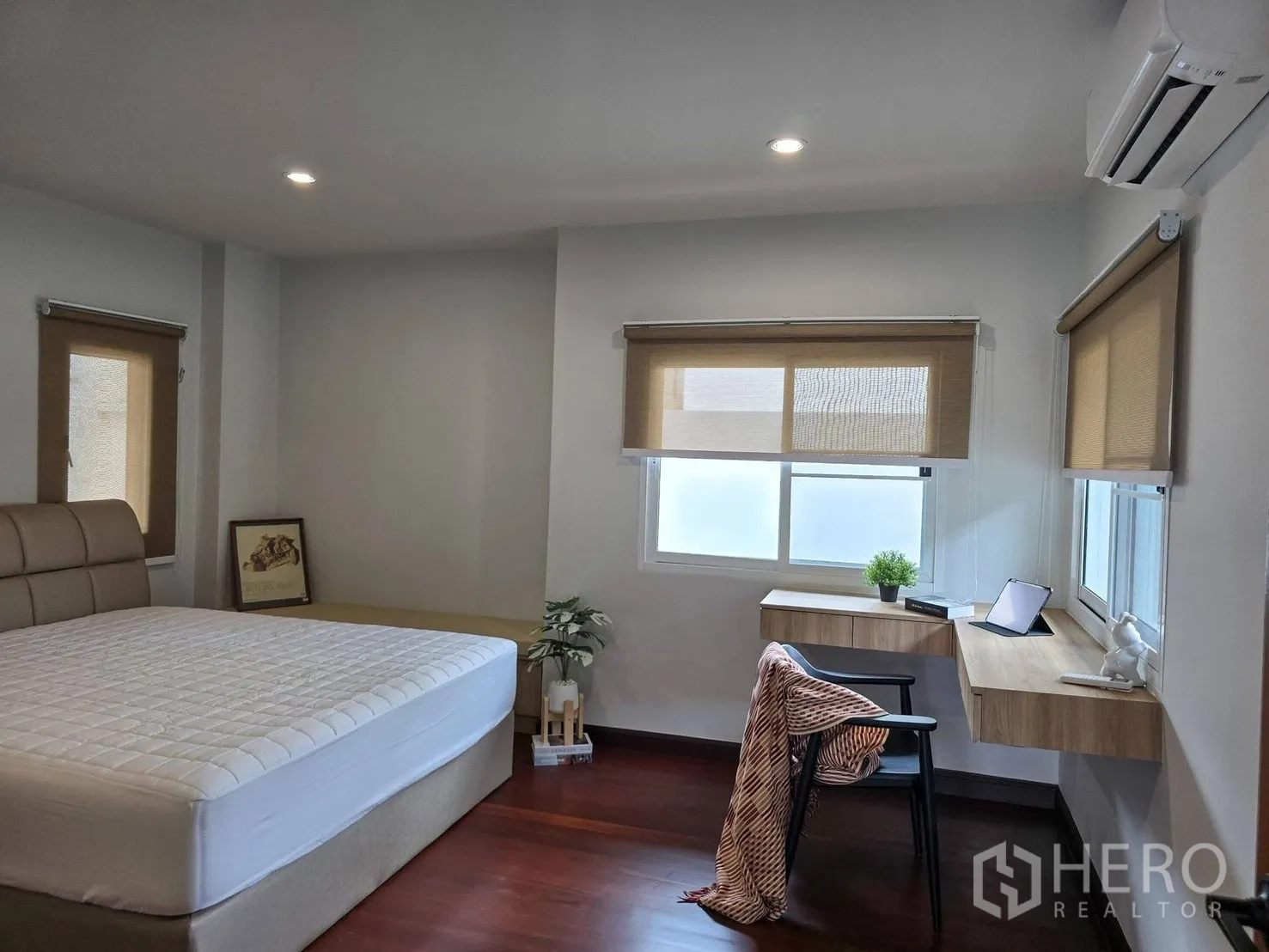 Detached House for rent in Suan Luang, Bangkok - Bedroom with study desk by large windows and an upholstered bed.