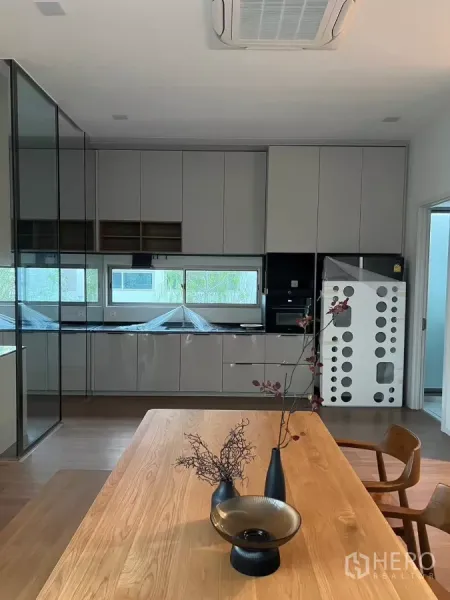 独立式住宅 出租在Saphan Sung, Bangkok - 现代厨房，整面收纳柜、横向采光窗与嵌入式电器。