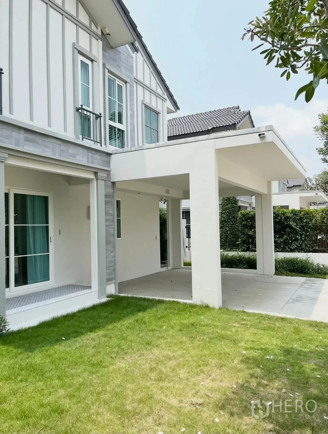 Detached House for rent in Bang Phli, Samut Prakan - Modern two-storey house exterior with covered carport and green lawn.