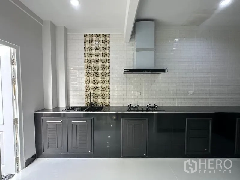 บ้าน ขายในLam Luk Ka, Pathum Thani - ห้องครัวบิลท์อิน ตู้สีดำ เตาแก๊ส เครื่องดูดควัน ผนังกระเบื้องซับเวย์