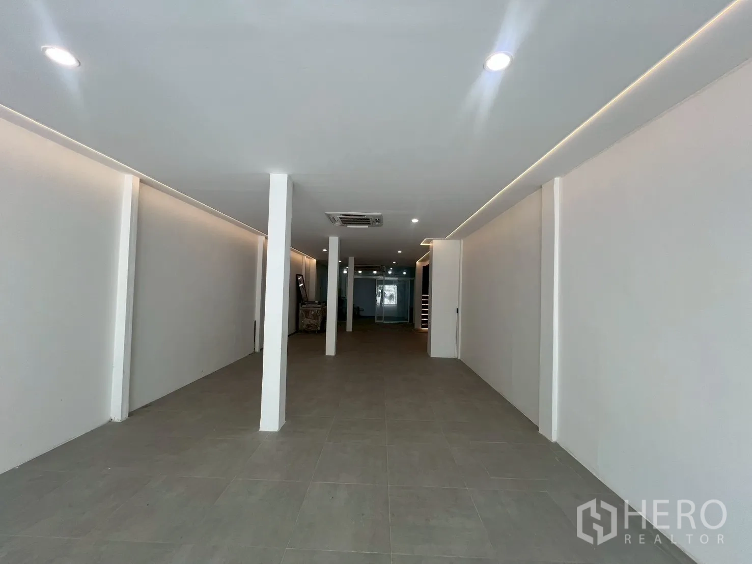 Home Office for rent in Watthana, Bangkok - Long open-plan hall with downlights and neutral floor tiles.