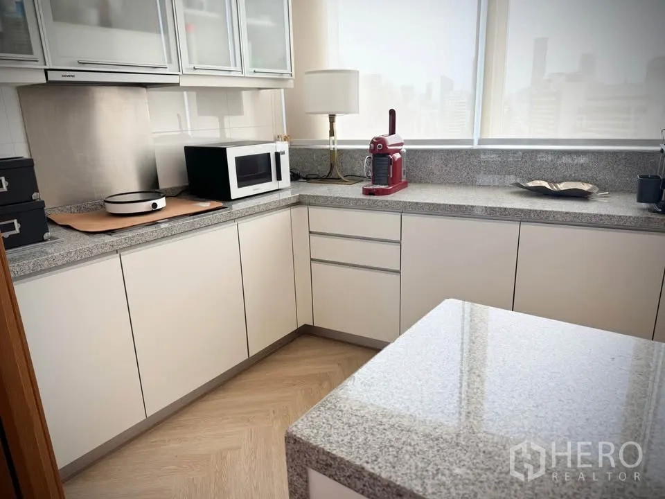 คอนโด for rent or sale in Khlong Toei, Bangkok - ครัวรูปตัวแอลพร้อมไอส์แลนด์ท็อปหินแกรนิต ได้แสงธรรมชาติผ่านมู่ลี่.