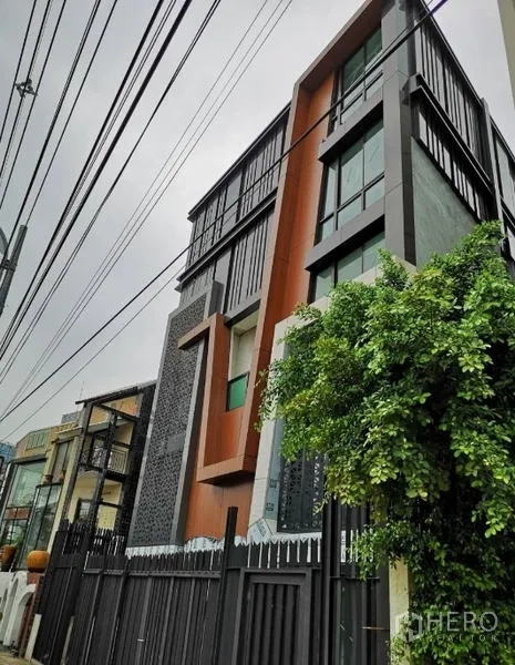 独立商业地产 出租在Chatuchak, Bangkok - 带几何饰面的现代独栋建筑侧视图，通高落地窗。