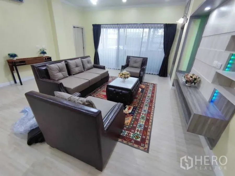 คอนโด ให้เช่าในKhlong Toei, Bangkok - ห้องนั่งเล่นกว้างของคอนโด President Park พร้อมโซฟาหนัง ผนังบิลท์อิน พรมลาย และหน้าต่างผ้าม่านบานใหญ่