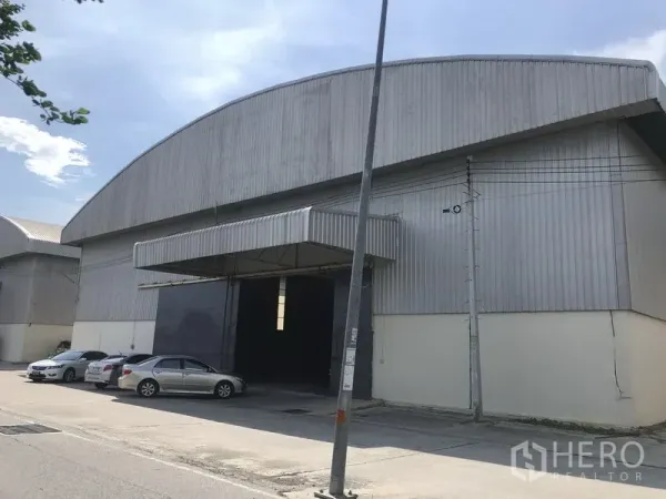 货栈 出租在Phan Thong, Chon Buri - 春武里府Amata Nakorn园区仓库正立面，金属外墙、装卸雨棚与停车位。