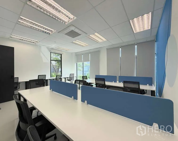 Office Space for rent in Huai Khwang, Bangkok - Bright serviced office with long bench desks, blue partitions, task chairs, large windows and LED lighting.