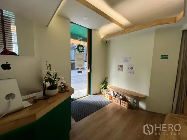 พื้นที่ขายปลีก ให้เช่าในKhlong Toei, Bangkok - โถงต้อนรับเคาน์เตอร์ไม้ ที่นั่งรอ และประตูกระจกสู่ถนน.