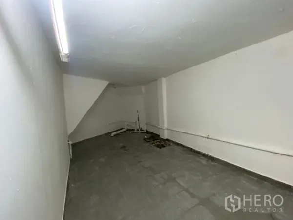 อาคารพาณิชย์ ให้เช่าในKhlong Toei, Bangkok - ห้องเก็บของหรือพื้นที่หลังร้าน ผนังสีขาว พื้นกระเบื้อง และไฟนีออนยาว.