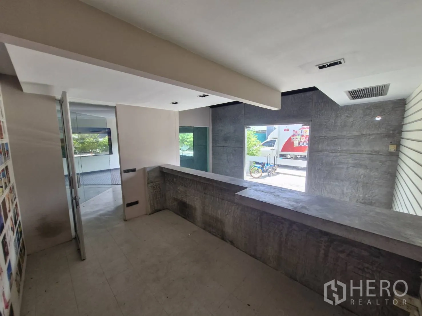Warehouse for rent in Suan Luang, Bangkok - Reception counter area with concrete finish and a window to the outside.