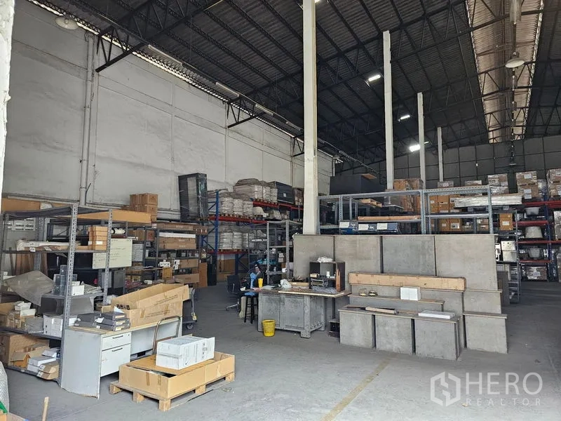 คลังสินค้า ให้เช่าในKhlong Toei, Bangkok - ภายในโกดังเพดานสูง โครงหลังคาเหล็ก ชั้นวางของ พื้นคอนกรีต และพื้นที่โต๊ะทำงาน