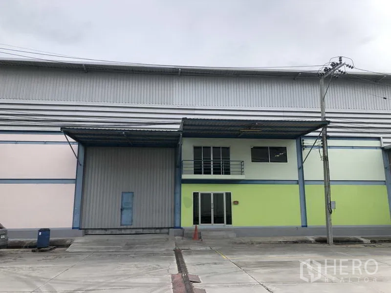 คลังสินค้า ให้เช่าในBang Phli, Samut Prakan - ด้านหน้าโกดังสมัยใหม่ พร้อมประตูโหลดสินค้าขนาดใหญ่ กันสาด และออฟฟิศ 2 ชั้น