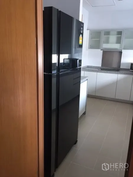 คอนโด ให้เช่าในKhlong Toei, Bangkok - ครัวแยก ตู้เย็นประตูคู่สีดำ ตู้บิวท์อินสีขาว และเคาน์เตอร์หินแกรนิต