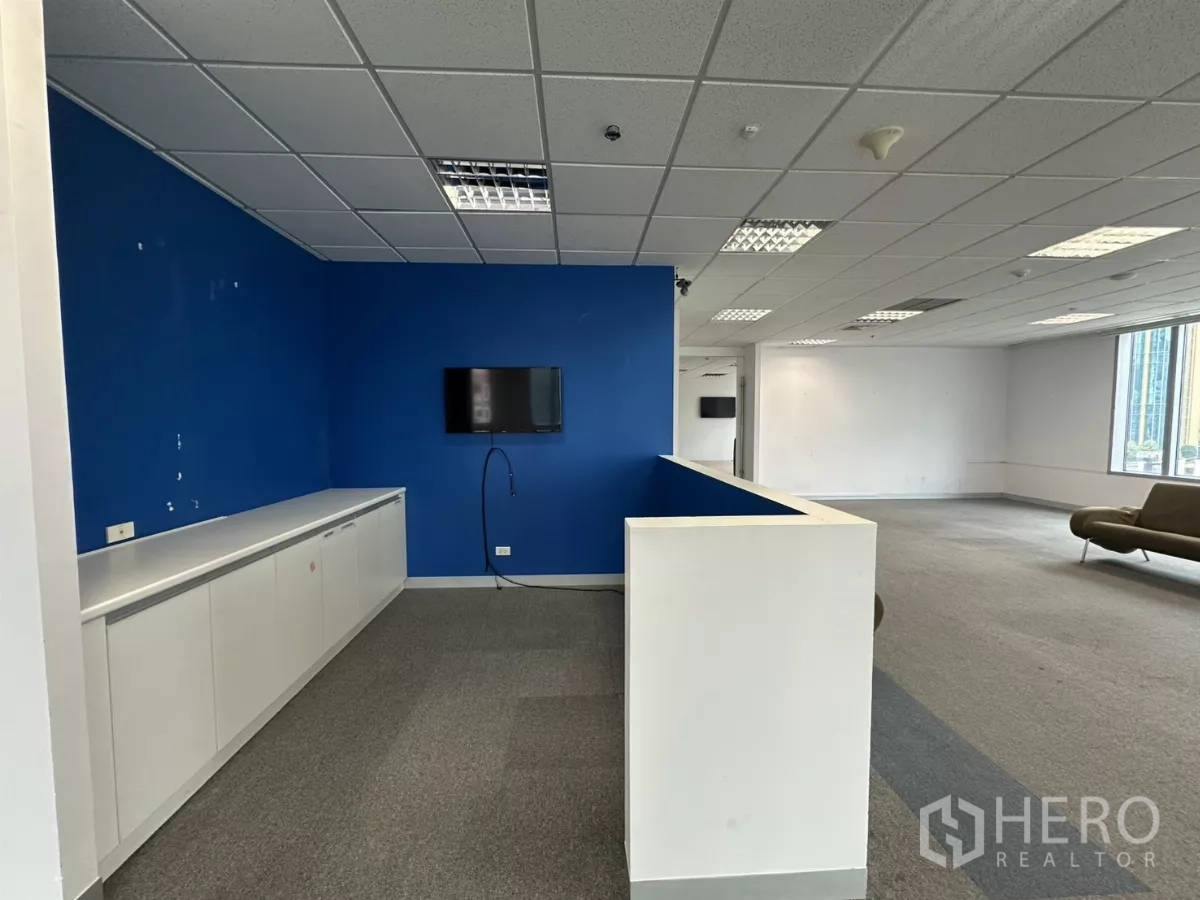 办公空间 出租在Watthana, Bangkok - 接待台、蓝色特色墙、储物柜与休闲座椅。