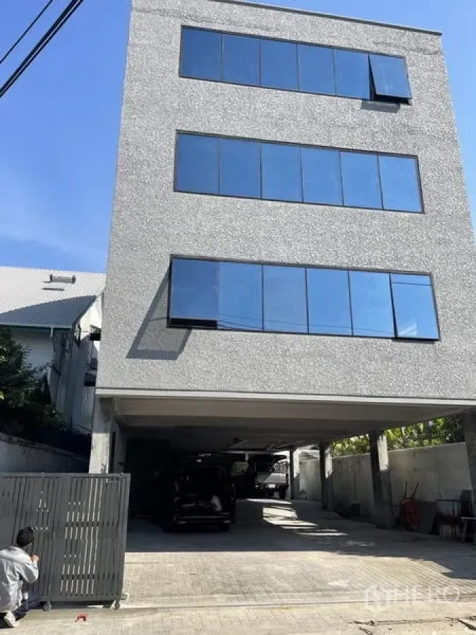 带办公室的家 出租在Phaya Thai, Bangkok - 现代多层住宅式办公楼外观，大片玻璃窗与有顶停车区。