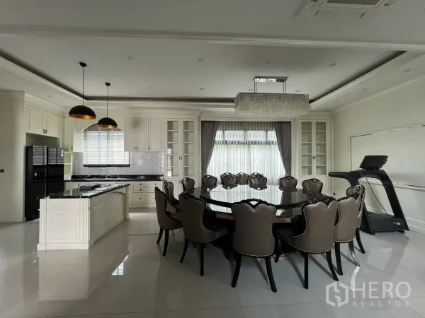 Detached House for rent or sale in Prawet, Bangkok - Open kitchen and dining room with pendant lights and round table seating.