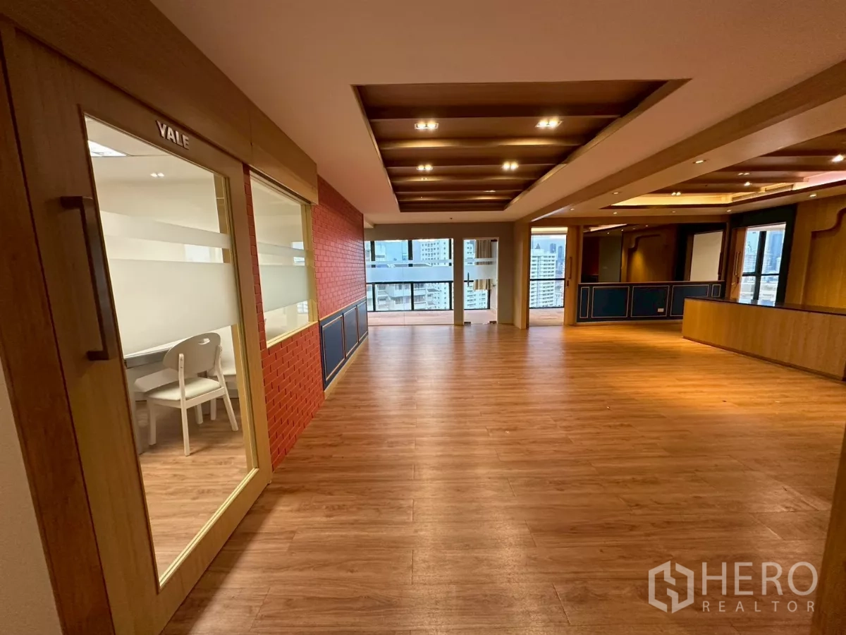 Office Space for rent in Khlong Toei, Bangkok - Open workspace with a red brick feature wall, glass-partitioned meeting room, and balcony city view.