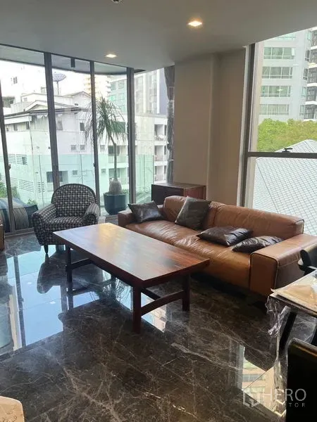 คอนโด ให้เช่าในWatthana, Bangkok - ห้องนั่งเล่นพื้นหินอ่อน พร้อมโซฟาหนัง โต๊ะไม้ และกระจกเต็มบานมองเห็นวิวเมือง