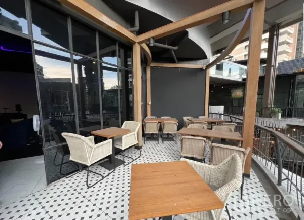 พื้นที่ขายปลีก ให้เช่า - เทอเรซกลางแจ้งมีเก้าอี้หวาย โต๊ะเล็ก และพื้นกระเบื้องลายเรขาคณิต