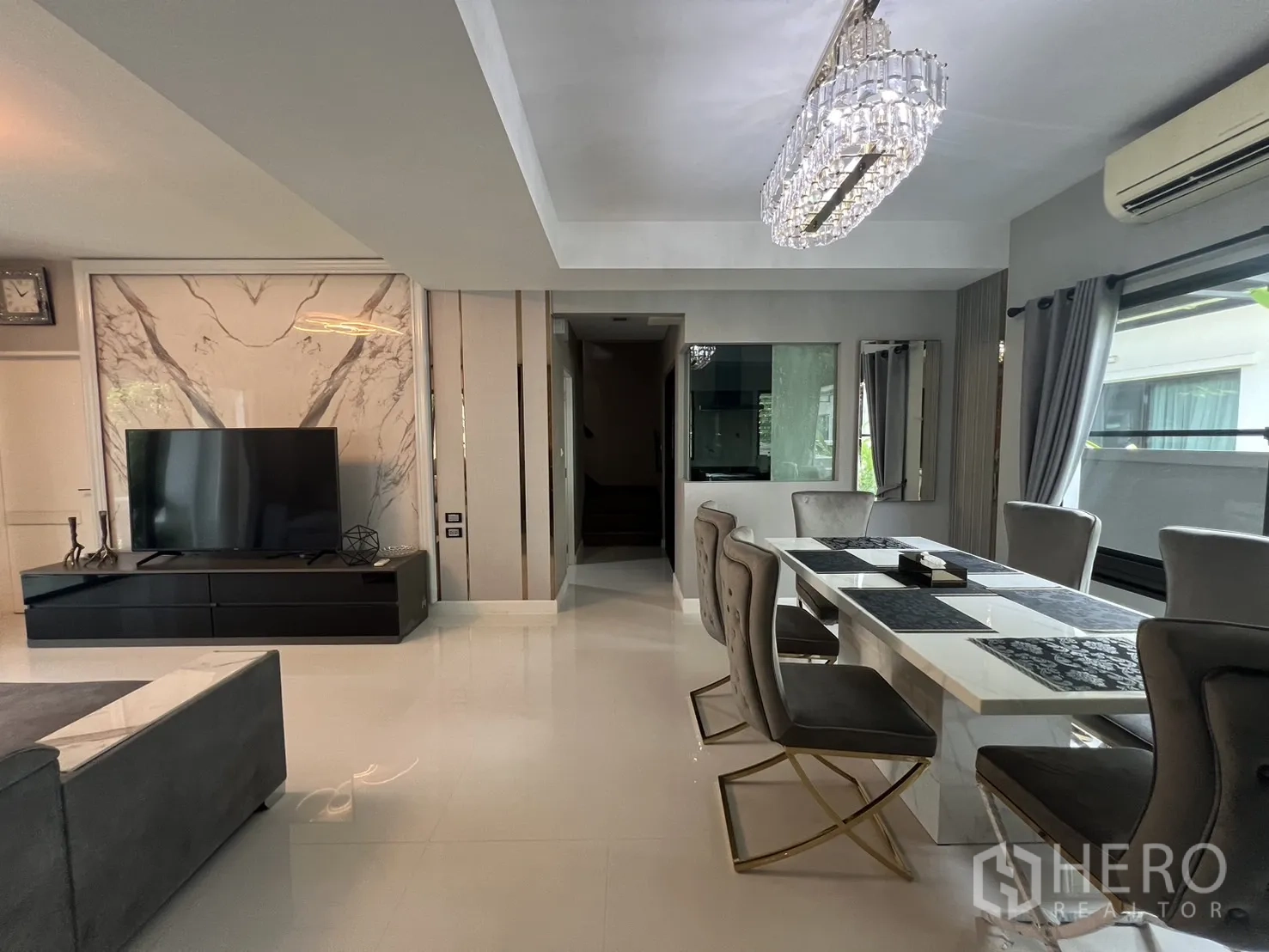 Detached House for rent in Bang Phli, Samut Prakan - Open-plan living and dining room with glossy floors and contemporary lighting.