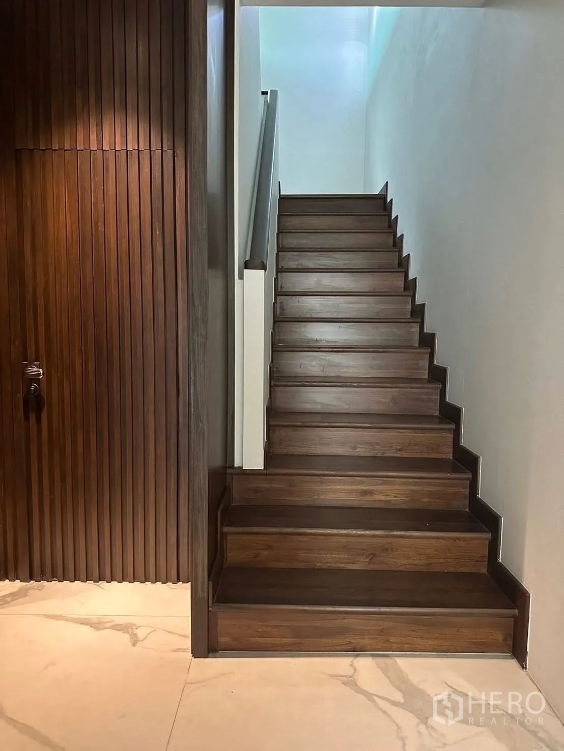 บ้าน ให้เช่าในLat Krabang, Bangkok - บันไดไม้จากพื้นกระเบื้องลายหินอ่อน ข้างผนังไม้ซี่