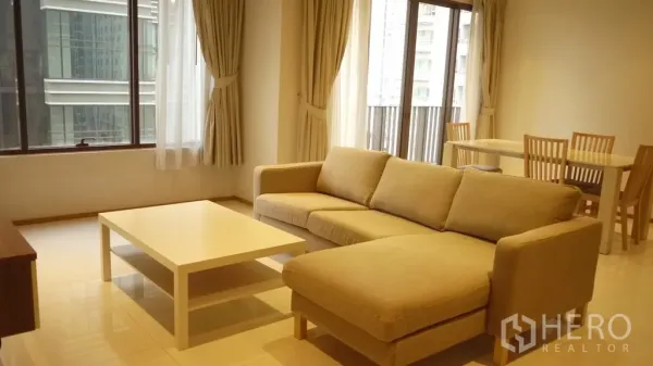 คอนโด ให้เช่าในKhlong Toei, Bangkok - โถงรับแขกและทานอาหารแบบเปิดโล่ง พร้อมโซฟา โต๊ะกลางสีขาว ชุดโต๊ะอาหาร และประตูกระจกออกระเบียง วิวเมือง