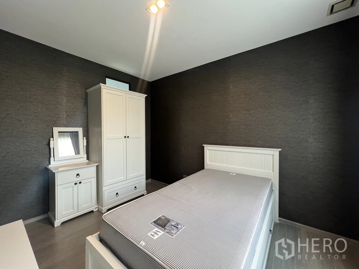 联排别墅 出租在Lat Phrao, Bangkok - 客臥配白色家私，衣櫃與梳妝台，深色特色牆。