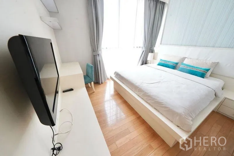 公寓 出租或出售在Watthana, Bangkok - 采光充足的卧室，双人大床、壁挂电视与落地窗帘。