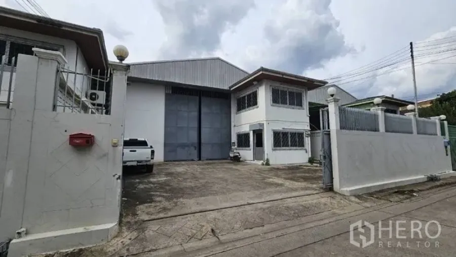 货栈 出租在Lak Si, Bangkok - 仓库外观，带围墙大门、宽阔车道及两层办公室。