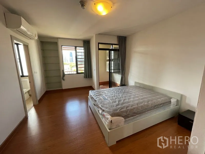 Condominium for rent in Watthana, Bangkok - Expansive living room view showing TV console, sofa set and dining area.