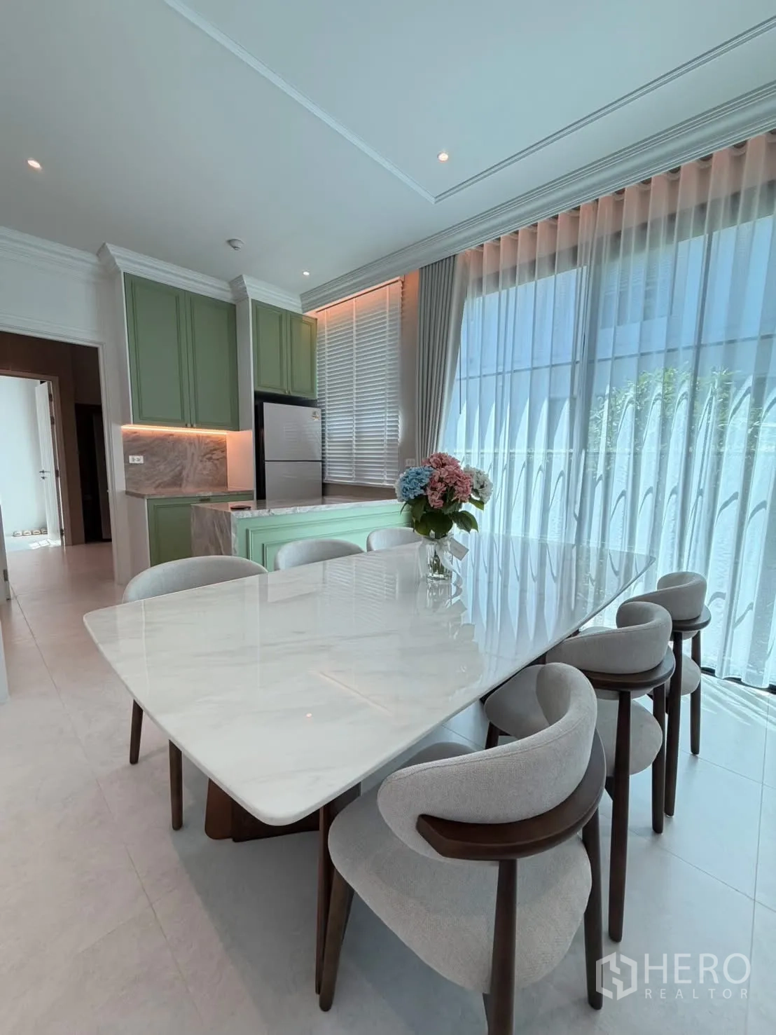 Detached House for rent in Saphan Sung, Bangkok - Dining area with marble-top table, six chairs, and mint-green cabinetry.