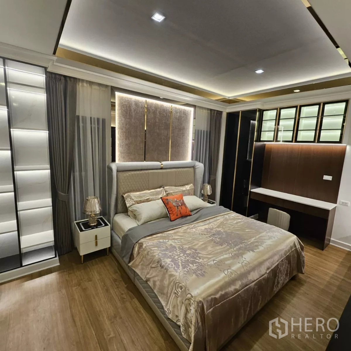 Detached House for rent in Bang Phli, Samut Prakan - Master bedroom with feature ceiling lighting, large bed, bedside tables, built-in wardrobes and work desk.