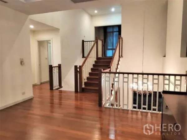 独立式住宅 出租在Watthana, Bangkok - 室内过道与木质楼梯，白色栏杆与高挑空间。