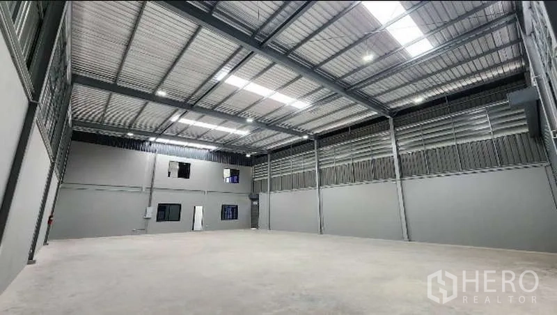 Factory for rent in Bang Bo, Samut Prakan - Open warehouse bay with ventilated steel panels and concrete floor