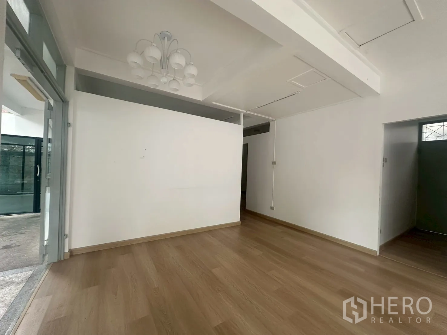 บ้าน ให้เช่าในWatthana, Bangkok - ห้องขนาดกะทัดรัดพร้อมโคมไฟแขวน พื้นไม้ และทางออกสู่เฉลียงกระจก.