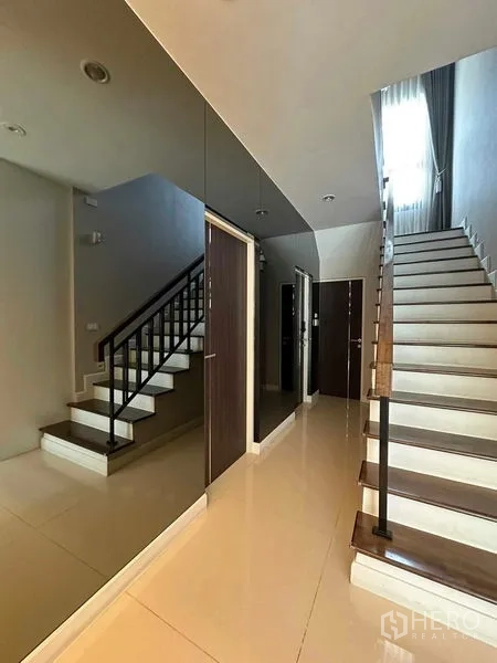 Detached House for sale in Prawet, Bangkok - Stair hall with glossy tiles, multiple doors and straight-run stairs.