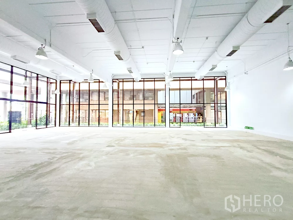 Office Space for rent in Watthana, Bangkok - Bright shell-and-core office with panoramic windows and neutral concrete flooring.