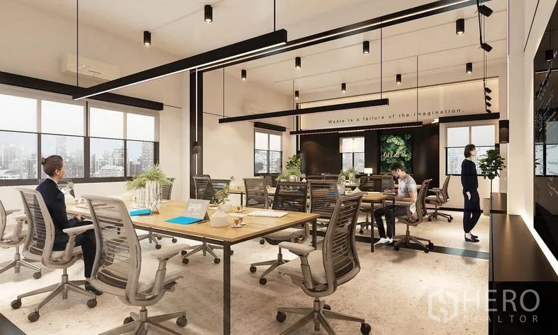 Office Space for rent in Khlong Toei, Bangkok - Bright open-plan office with long wooden worktables, ergonomic chairs, large windows with city views, linear pendant lighting, indoor plants, and a polished concrete floor.