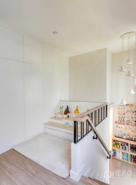 Detached House for rent in Bang Khun Thian, Bangkok - Stair landing with black handrail, pendant lights and a tidy display niche.