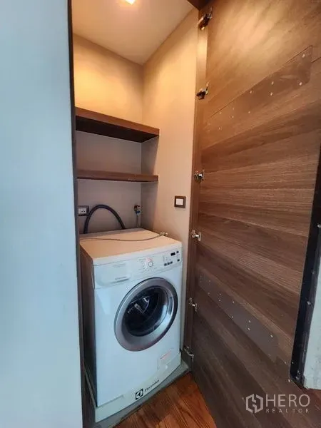 公寓 出租在Bang Rak, Bangkok - 紧凑洗衣柜，内置滚筒洗衣机与置物层板。