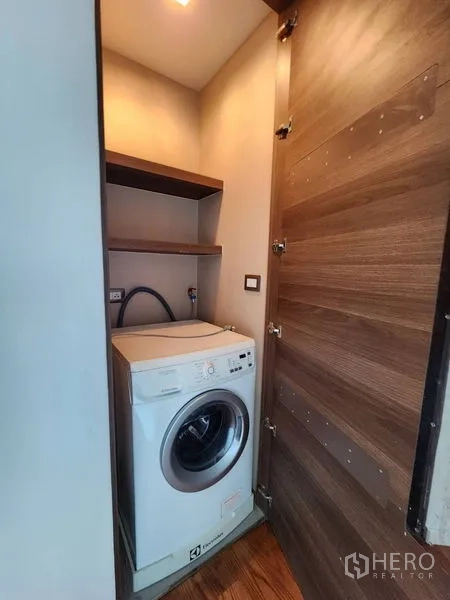 公寓 出租在Bang Rak, Bangkok - 紧凑洗衣柜，内置滚筒洗衣机与置物层板。