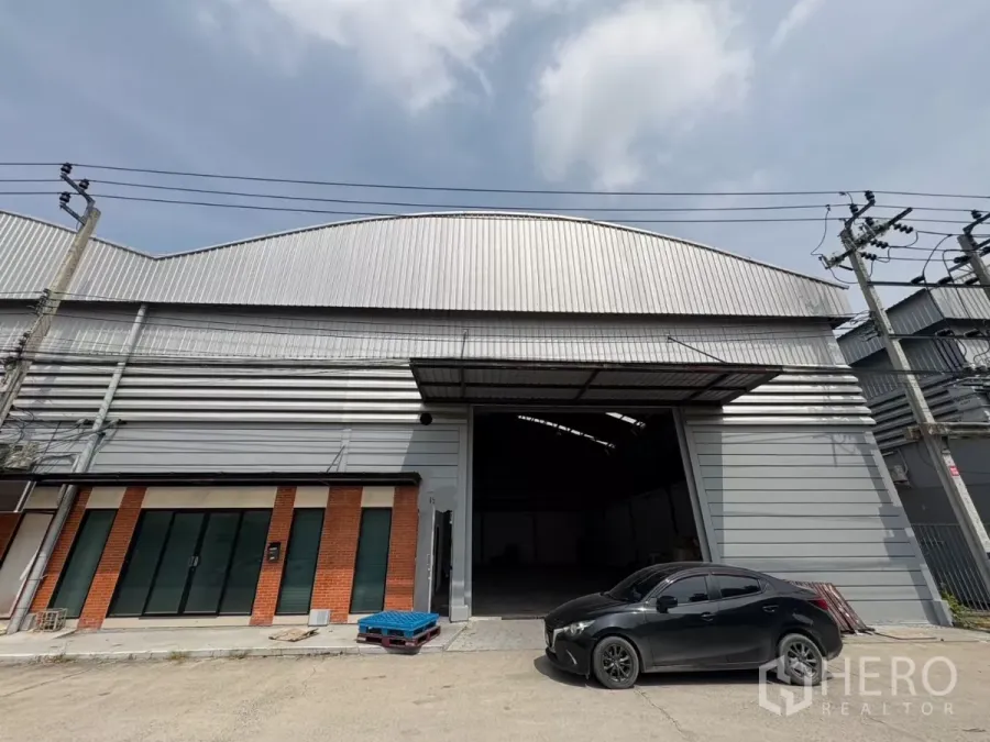 Warehouse for rent in Bang Phli, Samut Prakan - Steel-clad warehouse facade with wide loading entrance and parking in Bang Phli.