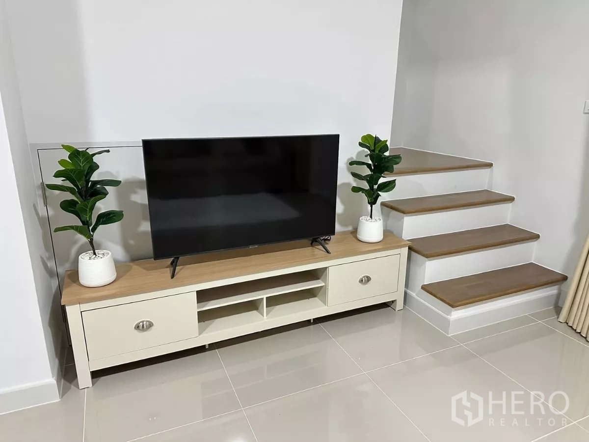 ทาวน์เฮาส์ ให้เช่าในBang Phli, Samut Prakan - ชั้นวางทีวีข้างบันได ตกแต่งด้วยต้นไม้กระถาง