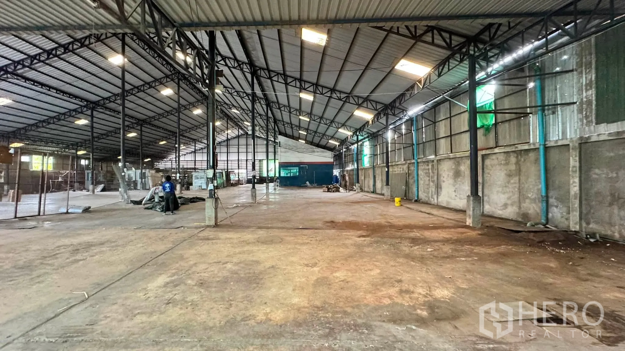 Warehouse for rent in Bang Khen, Bangkok - Long view of warehouse with high roof, perimeter walls, and open storage zones.